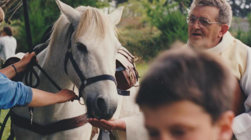 Pardon de Saint-Gildas au large de Penvénan (22). Le prêtre donne du pain béni aux chevaux. Photo : Daniel Giraudon