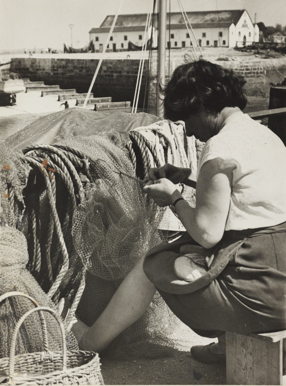 Femme réparant un filet. Photo : Charles Barmay 1909 -1993).  Source : collections du Musée de Bretagne.