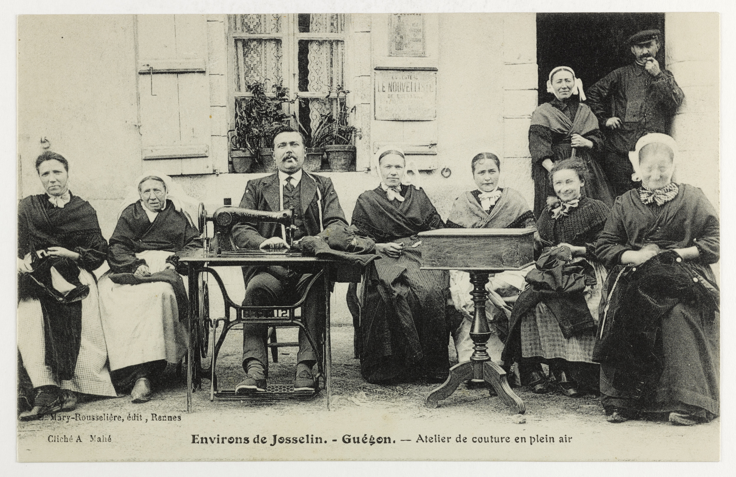 Atelier de couture en plein air à Guégon (56) au début du XXe siècle. Un groupe de couturières posent : Eugénie Trévedy, la femme du tailleur, Julienne Lecoq, courbée, Françoise Danet, et Léon Trévedy, le tailleur. Source : Collections du Musée de Bretagne. 